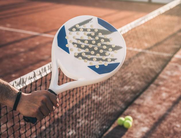 Man hand grabbing a padel racket